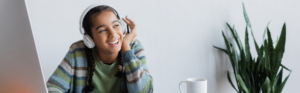 Photo shows a girl listening through headphones.