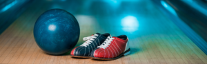 Photo shows a bowling ball and shoes.