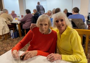 Picture shows Kathy and Rose, 2 clients, enjoying a fish and chip lunch at one of our social activities.