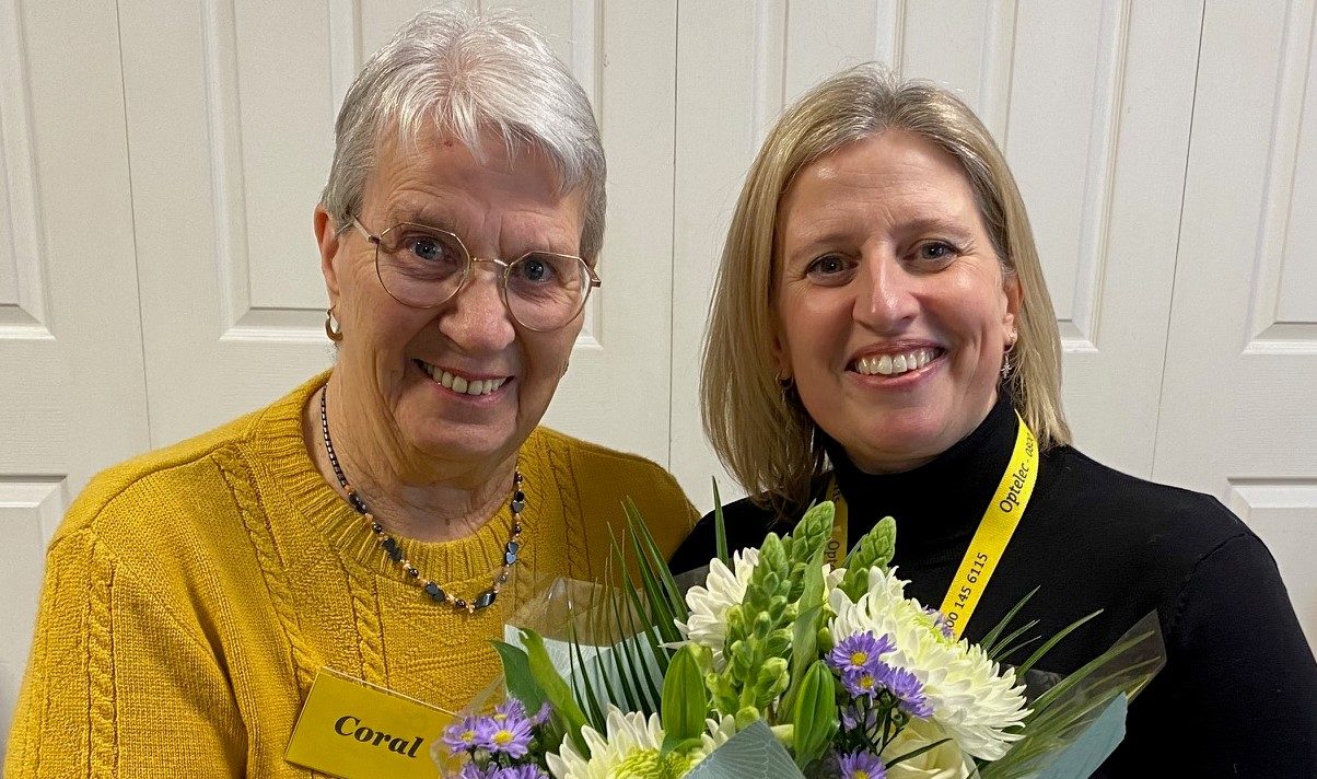 Picture shows CEO Lucy presenting Coral with flowers at the Macular Group.