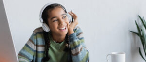 Photo shows a girl listening through headphones.